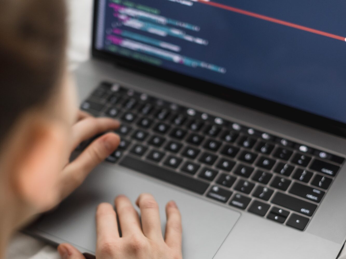 Young female programmer writes program code on a computer laptop in the bed at home. remote work